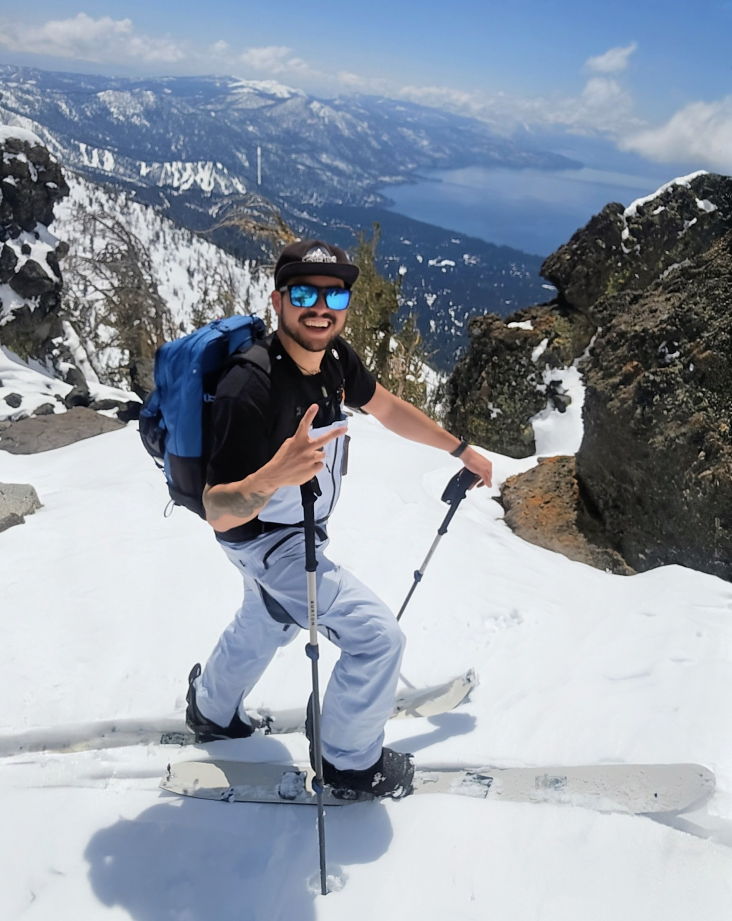 Al Travaglini splitboarding on a Sierra ridgeline with Lake Tahoe in the distance